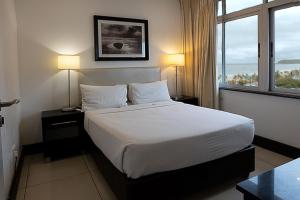 een hotelkamer met een bed en een groot raam bij Parade Hotel in Durban