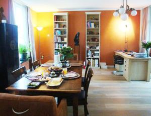 a living room with a table and chairs and a dining room at Abeelboom B and B in Middelburg