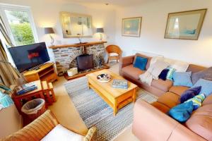 a living room with a couch and a tv at CROYDE HALLGREIN 4 Bedrooms in Croyde