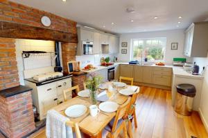 a kitchen with a wooden table and a brick wall at CROYDE HALLGREIN 4 Bedrooms in Croyde
