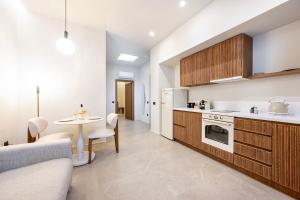 a kitchen with a table and a white refrigerator at Volaka Luxury Suites in Kos