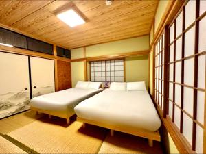 two beds in a room with two windows at Gen-en Private Hideaway Villa, Izu Forest in Izu