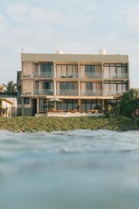 a building on the beach next to the water at Soul Temple Boutique Hotel ADULTS ONLY in Ahangama