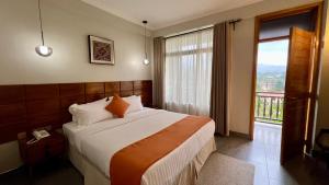a bedroom with a large bed and a large window at Iwandaa Boutique Hotel in Nkoanrua