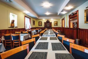 a long table in a restaurant with tables and chairs at Penzion UNA in Liptovský Ján