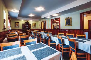 a dining room with white tables and chairs at Penzion UNA in Liptovský Ján