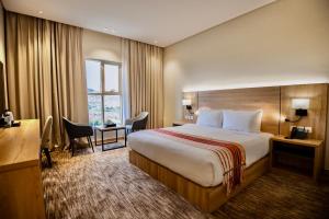 a hotel room with a bed and a desk at W Suites Hotel Sama Abha in Abha