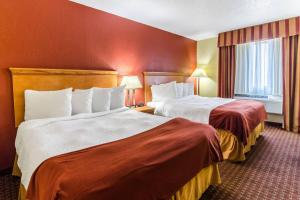 a hotel room with two beds and a window at Rodeway Inn & Suites Jacksonville near Camp Lejeune in Jacksonville +27 photos