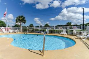 a small swimming pool with chairs and an american flag at Rodeway Inn & Suites Jacksonville near Camp Lejeune in Jacksonville