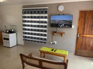 a kitchen with a table and a clock on the wall at No7 Mc Intyre Guest House in Sasolburg