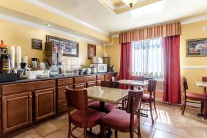 a kitchen with a table and chairs in a room at Rodeway Inn & Suites Jacksonville near Camp Lejeune in Jacksonville