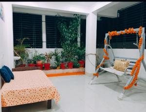 a room with a bed and a chair on a porch at Anand Nivas Homestay 10 Mins from Mandir in Deoghar