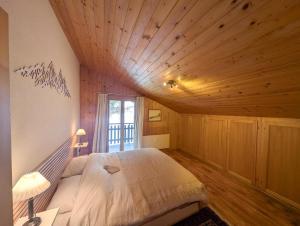 a bedroom with a bed and a wooden ceiling at Cocon Alpin: Vue Imprenable, Central & Calme in Saint-Luc