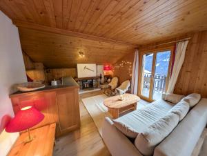 a living room with a couch and a table at Cocon Alpin: Vue Imprenable, Central & Calme in Saint-Luc