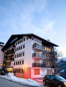 a building with a car parked in front of it at Cocon Alpin: Vue Imprenable, Central & Calme in Saint-Luc