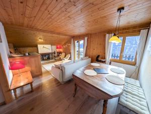a living room with a wooden ceiling and a table at Cocon Alpin: Vue Imprenable, Central & Calme in Saint-Luc