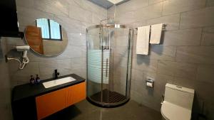 a bathroom with a shower and a sink and a mirror at Iwandaa Boutique Hotel in Nkoanrua +29 photos