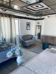 a bedroom with a bed and a couch at Euphoria Escape in Midrand +33 photos