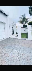 a white house with a stone driveway in front of it at Euphoria Escape in Midrand