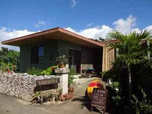 宫古岛Hotel Hibiscus的一栋房子前面有一块招牌