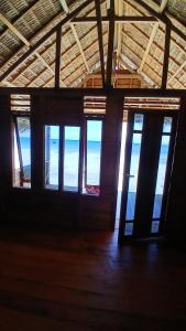 an empty room with windows in a building at Homestay Yenkop in Poelau Mansoear