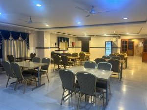 a dining room with tables and chairs and a room filled with tables and chairs at Hotel Vaishnavi in Hyderabad