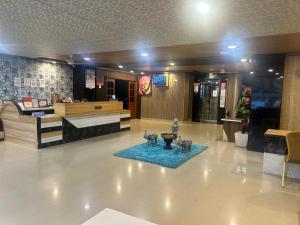 a lobby with a waiting area with statues on a blue rug at Hotel Vaishnavi in Hyderabad