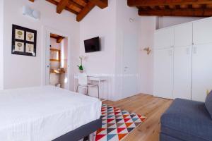 biała sypialnia z łóżkiem i niebieską kanapą w obiekcie B&B Mulino di Campese w mieście Campese +6 zdjęć