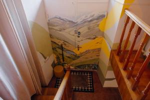 a staircase with a mountain mural on the wall at Friends Hostel in Tbilisi City