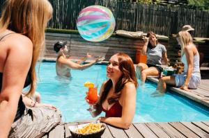 a group of people sitting in a swimming pool at Never at Home Green Point in Cape Town