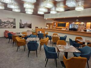 a restaurant with tables and chairs and a bar at Hotel Cascade in Most