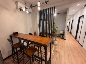 a dining room with a wooden table and chairs at Mini Urban Guest House in Kampong Pasang