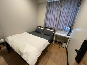 a small bedroom with a bed and a window at Mini Urban Guest House in Kampong Pasang