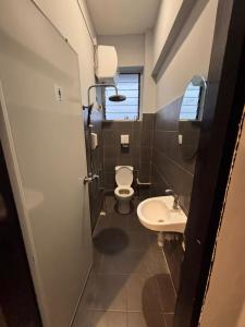 a small bathroom with a toilet and a sink at Mini Urban Guest House in Kampong Pasang