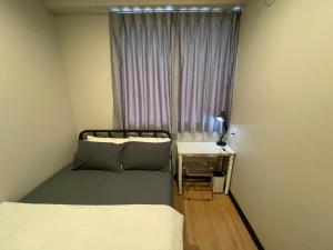 a small room with two beds and a window at Mini Urban Guest House in Kampong Pasang +4 photos