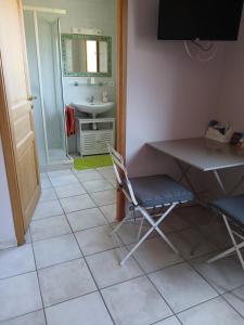 a room with a table and a chair and a sink at Les Haies Vives in Choisy