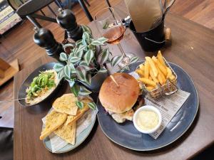 a table with two plates of food and a sandwich and french fries at The Peppercorn Shack in Kingscote +26 photos