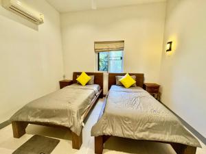 two beds in a room with a window at Sunset bay view villa krabi in Ban Khao Thong