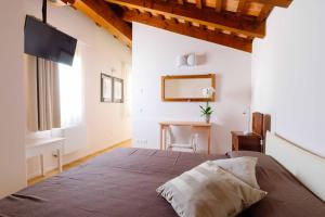 sypialnia z dużym łóżkiem i biurkiem w obiekcie B&B Mulino di Campese w mieście Campese