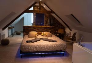 a bedroom with a large bed in a attic at Love Room Evasion Jacuzzi Sauna Hamamm in Saint-Cyr-sur-Loire