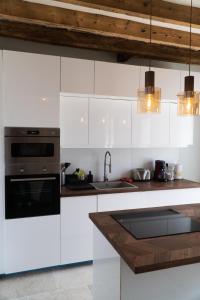 a kitchen with white cabinets and a sink at Love Room Evasion Jacuzzi Sauna Hamamm in Saint-Cyr-sur-Loire +7 photos