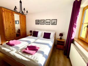a bedroom with a large bed with pink towels on it at Haus Thomas in Werfenweng