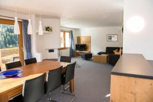 ein Esszimmer und ein Wohnzimmer mit Tisch und Stühlen in der Unterkunft Chasa Sot-Chaunt in Samnaun