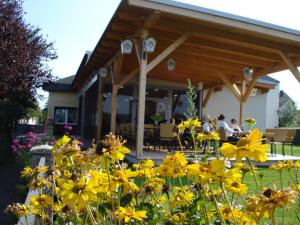 eine Gruppe gelber Blumen vor einem Haus in der Unterkunft Gasthof & Gästehaus Trummer in Horitschon