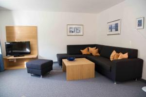 ein Wohnzimmer mit einer Couch, einem Tisch und einem Fernseher in der Unterkunft Chasa Sot-Chaunt in Samnaun
