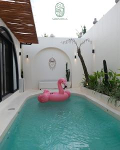 a pink inflatable flamingo in a swimming pool at Sampai Villa Kama in Ngaglik