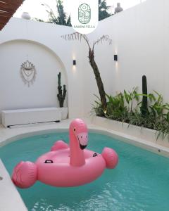 a pink swan float in a swimming pool at Sampai Villa Kama in Ngaglik +12 photos