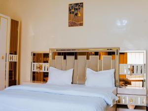 a bedroom with a large bed with white sheets and pillows at Camara Homes1 in Saint-Louis