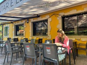 a woman sitting at a table outside a restaurant at Albergue O Beque in Moaña +37 photos
