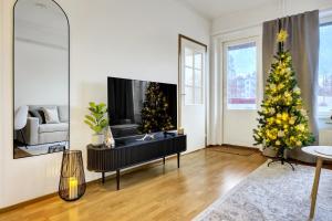 a living room with a christmas tree and a tv at Adorable Arctic Apartments - Private Sauna & Free Parking in Rovaniemi +52 photos